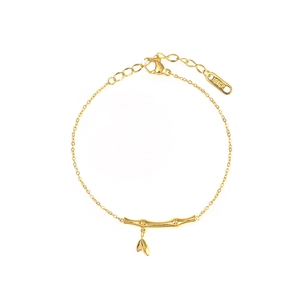 Bracciale a bambù minimalista placcato oro 18K con ciondolo a foglia su sfondo bianco