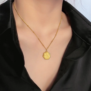 Collana in acciaio al titanio dorato con ciondolo floreale inciso su seta nera
