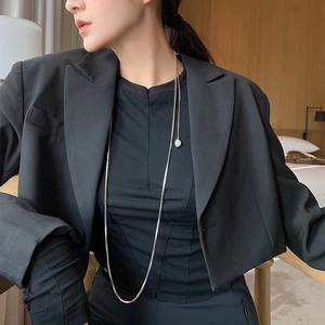 Minimalist long snake chain necklace with pearl pendant on black blazer for women