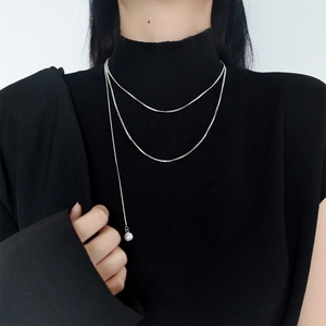 Minimalist silver multi-layer snake chain necklace with round pearl pendant on black knit