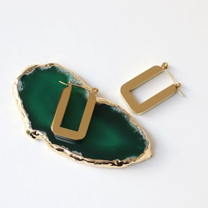 Minimalist rectangular gold titanium steel hoop earrings on a decorative green agate plate