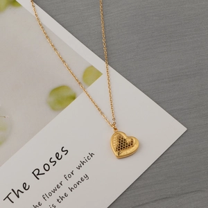 Gold heart necklace with honeycomb texture and Forever engraving on gray background