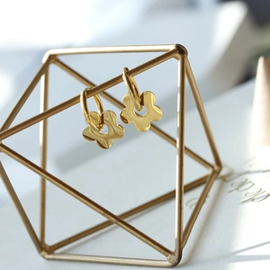 Boucles d'oreilles pétales dorées polies avec découpe ronde sur un support minimaliste