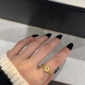 Gold vintage queen coin ring with textured mesh band shown on woman's finger