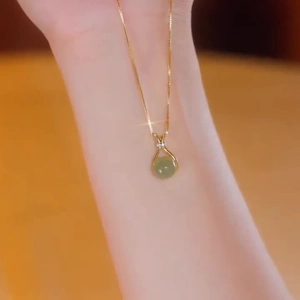 Elegante 18K vergoldete Titanstahlkette mit grünem Jade-Anhänger am weiblichen Hals