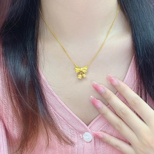 Collier muguet en or 18 carats avec pendentif nœud porté par un mannequin femme