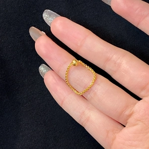 Minimalist gold chain ring for women featuring a polished bead on dark fabric background