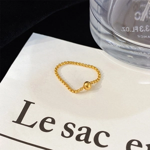 Minimalist gold chain ring with a shiny golden bead on white elegant display card