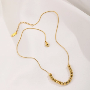 18K gold plated titanium snake chain necklace with fifteen polished beads on silk