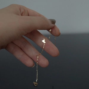 Minimalist gold plated titanium steel bracelet featuring three delicate heart charms