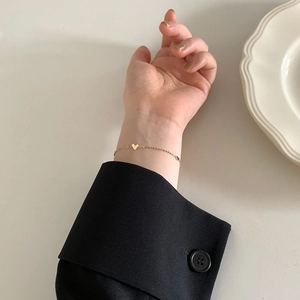 Minimalist gold heart bracelet featuring three solid heart pendants on a thin chain