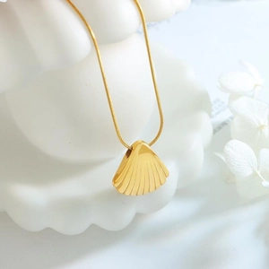 Luxueux collier doré avec pendentif en forme de coquillage éventail et texture striée
