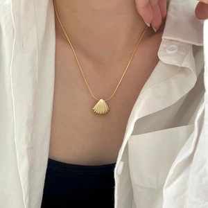 Élégant collier pendentif coquillage doré en forme d'éventail sur mannequin femme