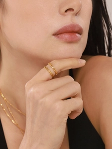 Detail of gold chain link ring and layered necklaces on model for a chic look