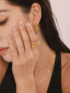 Detail of 18k gold plated stainless steel jewelry set with hammered texture rings