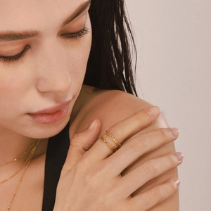 Minimalist gold chain texture rings and thin bead necklace set on elegant model