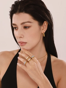 Detail showing stacked blue and white enamel cloud rings on a model's hand