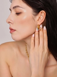 Detail von Goldohrringen mit bunten Zirkon-Pavé-Ringen, getragen von einem Modell