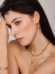 Detailsicht des Goldschmucksets mit Kristall-Ohrringen und geschichteten Ketten am Modell