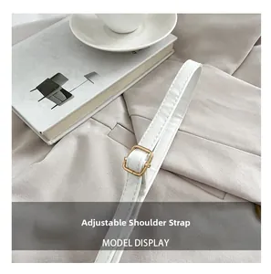 Detail of adjustable leather shoulder strap with gold buckle on vintage square crossbody bag