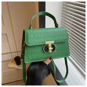 Detailed shot of bright green crocodile embossed leather bag with gold buckle hardware