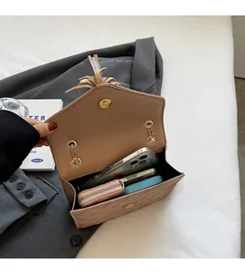 Interior view of quilted crossbody bag showing space for phone and wallet with tassel detail
