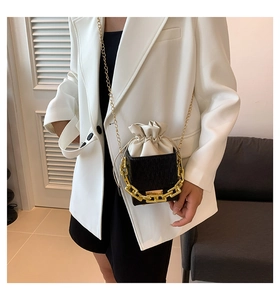 Detail of checkered square bucket bag with gold chain strap and drawstring closure