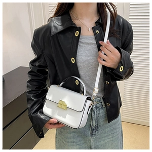 Detailed close-up of a white mini square bag featuring a gold turn-lock and black handle