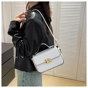 Detail shot of white crossbody bag with gold square buckle and sleek black edge paint