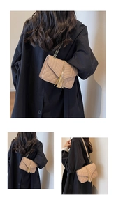 Detail view of beige quilted chain bag with elegant gold tassel and V-stitch pattern