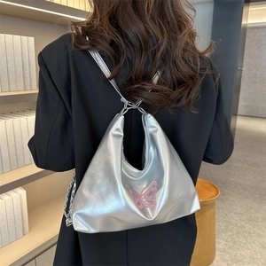 Silver metallic PU leather backpack with pink butterfly embroidery on model's back