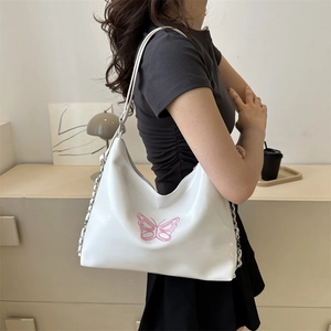White faux leather shoulder bag featuring pink butterfly embroidery and metal chain