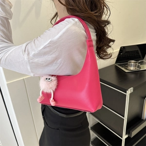 Minimalist bright pink leather underarm bag with cute plush monster charm for women