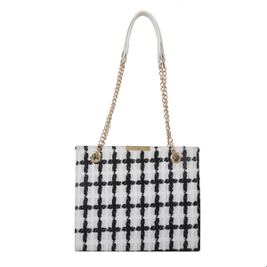 Classic black and white tweed checkered tote bag with gold chain strap on white background