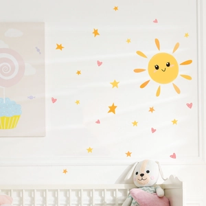 Cartoon sun and yellow stars wall stickers applied over a white crib in a cozy nursery