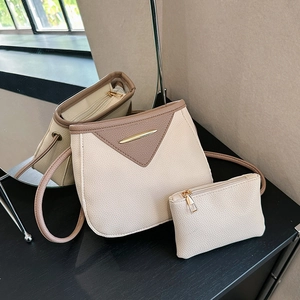 Detail of contrast stitching bucket bag with lychee pattern leather and gold hardware