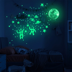 Luminous astronaut wall stickers with moon and stars glowing in the dark room