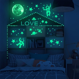 Glow-in-the-dark astronaut and moon wall stickers showing green fluorescent light at night