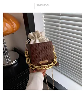 Brown checkered square bucket bag with gold chain and cream drawstring closure