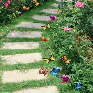 Vibrant double-layer butterfly garden stakes set against a scenic backyard stone path
