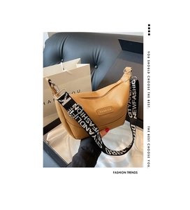 Détail du sac en cuir litchi marron caramel avec large bandoulière lettrée