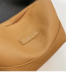 Détail du cuir à grain litchi et de la fermeture éclair du sac à bandoulière en croissant