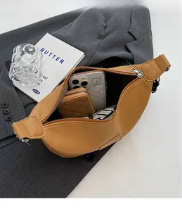 Vue de dessus montrant la capacité intérieure d'un sac bandoulière croissant camel