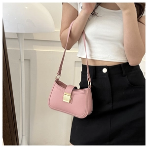 Sac bandoulière rose en cuir minimaliste avec fermoir doré porté par un mannequin en t-shirt
