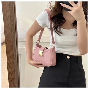 Borsa a spalla in pelle rosa con chiusura dorata mostrata in un selfie allo specchio
