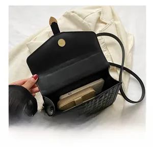 Interior view of black quilted crossbody bag showing capacity for phone and wallet