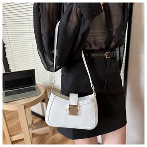 Détail du sac à bandoulière en cuir blanc avec boucle dorée sur un mannequin femme