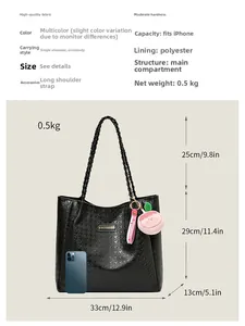Détail d'un sac cabas noir avec poignées tressées et pendentif pêche montrant les dimensions