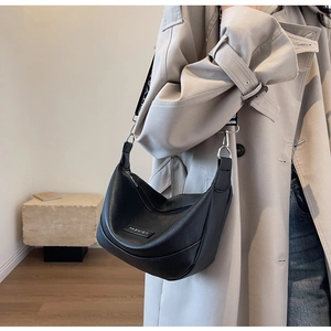 Détail du sac hobo en cuir grainé noir avec plaque de mode et bandoulière jacquard