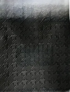 Gros plan sur la texture gaufrée pied-de-poule du sac cabas en cuir noir pour femme
